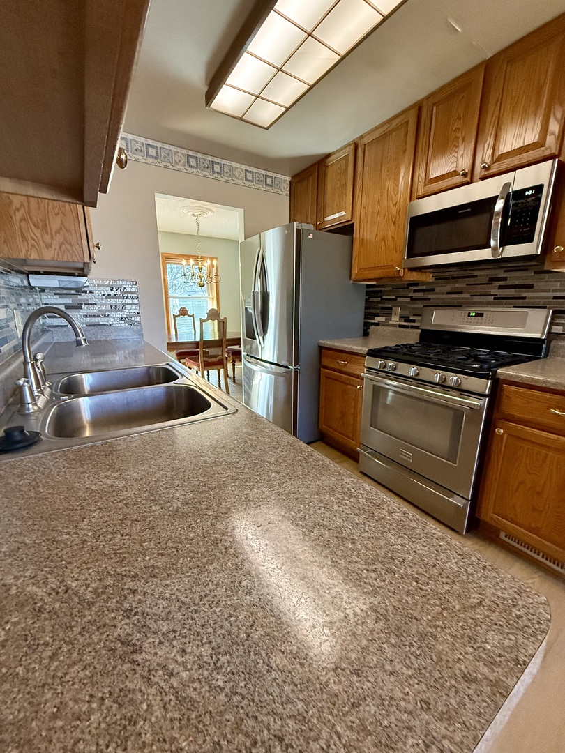 8408 49th Street Coal Valley, IL 61240 - Photo 13 of 43 a kitchen with stainless steel appliances granite countertop a sink stove and refrigerator