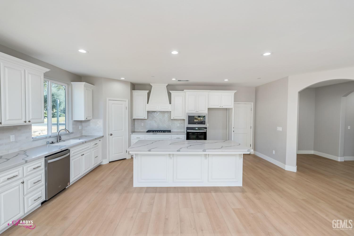 Undisclosed Address Bakersfield, CA 93306 - Photo 12 of 51 a large kitchen with stainless steel appliances a white stove top oven and white cabinets