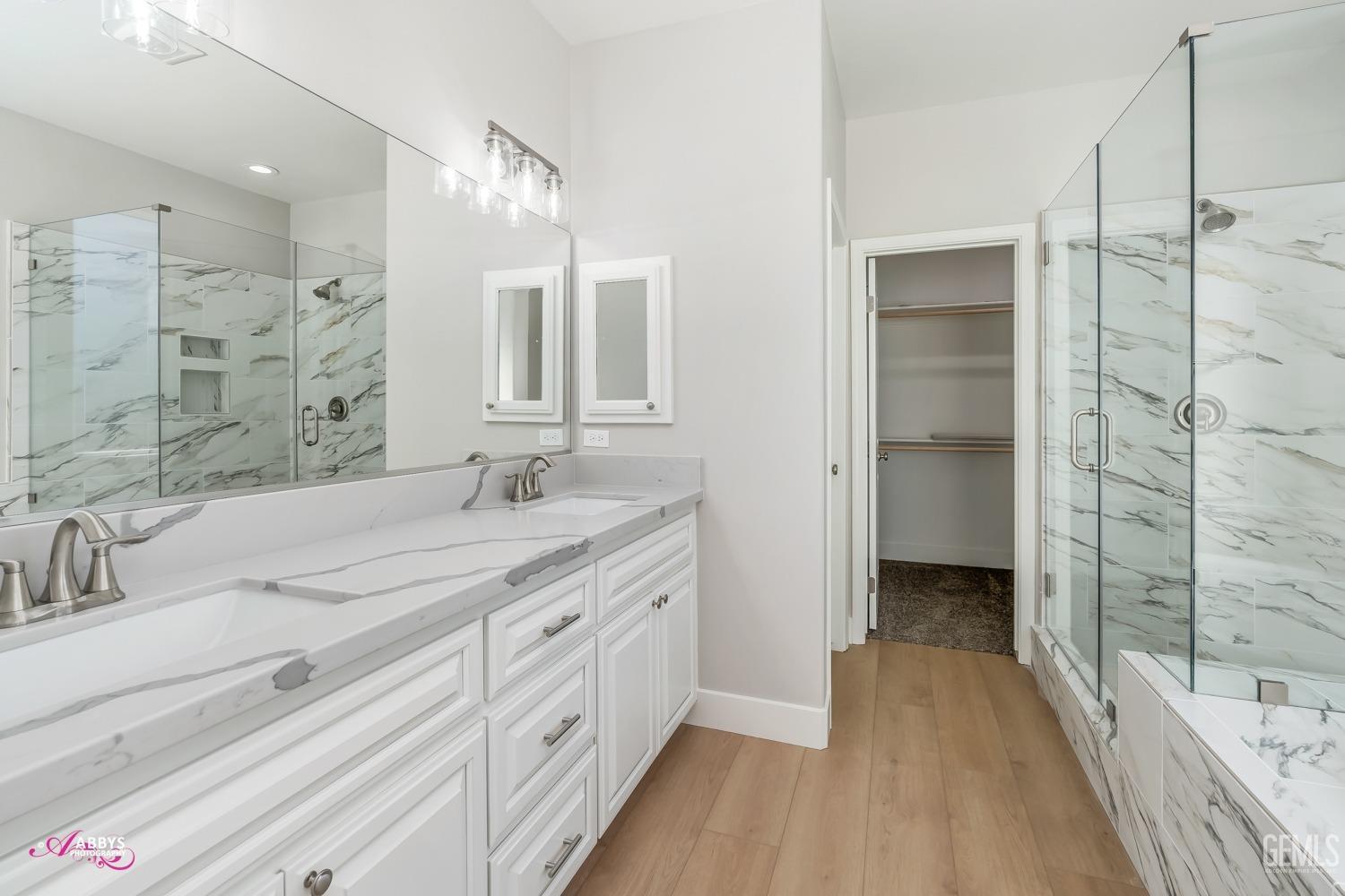 Undisclosed Address Bakersfield, CA 93306 - Photo 25 of 51 a spacious bathroom with a shower sink double vanity and mirror