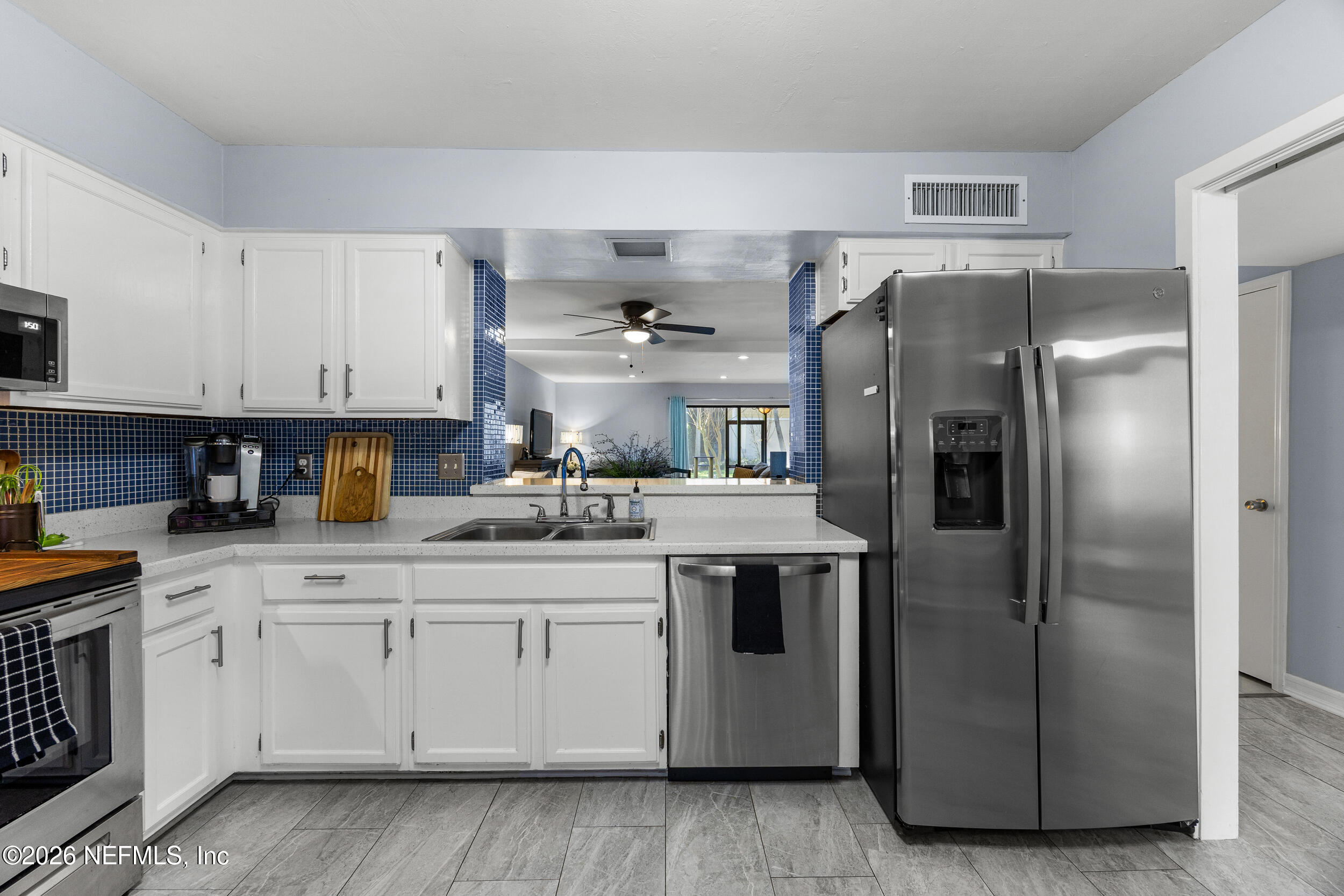 7852 Playa Del Rey Court Jacksonville, FL 32256 - Photo 8 of 33 a kitchen with stainless steel appliances granite countertop a refrigerator a sink and white cabinets