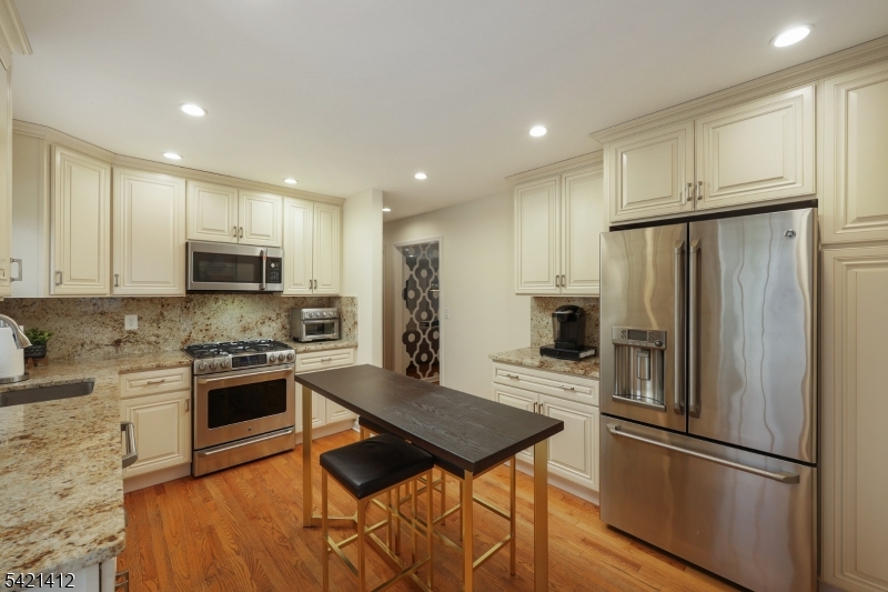 178 Tillotson Road Fanwood, NJ 07023 - Photo 9 of 38 a kitchen with stainless steel appliances wooden floor and a refrigerator