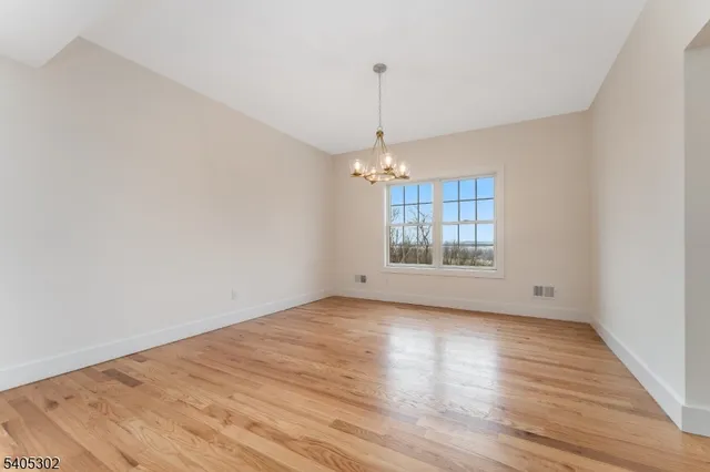 a large kitchen with stainless steel appliances granite countertop a stove a sink a refrigerator and a wooden cabinets