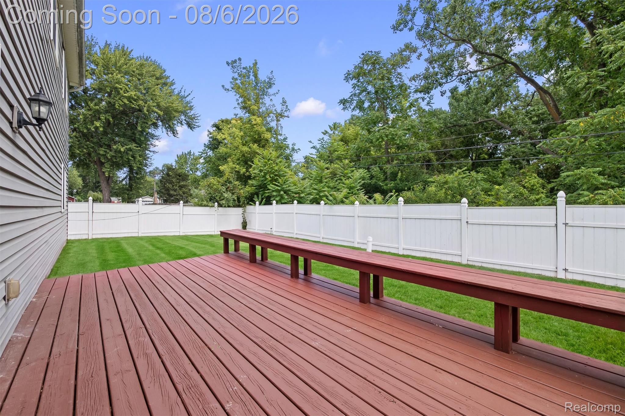 4427 Hannan Road Wayne, MI 48184 - Photo 32 of 33 Expansive outdoor deck with rich red-brown wood-finish planks and built-in bench seating