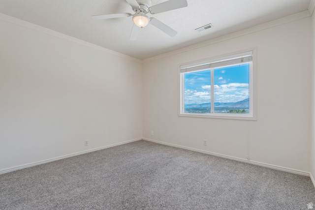 14883 Tooele Lane Draper, UT 84020 - Photo 29 of 49 Bright room featuring a large window showcasing distant mountains and a vibrant sky, neutral wall paint, gray carpeting, white baseboards, and a ceiling fan with integrated lighting