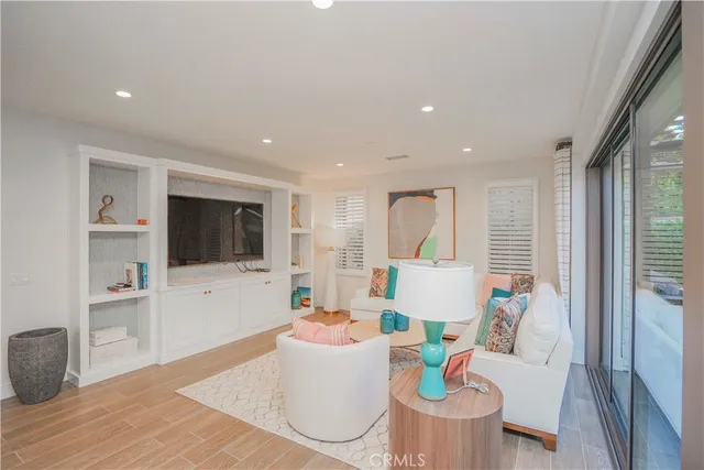 a living room with furniture a flat screen tv and kitchen view