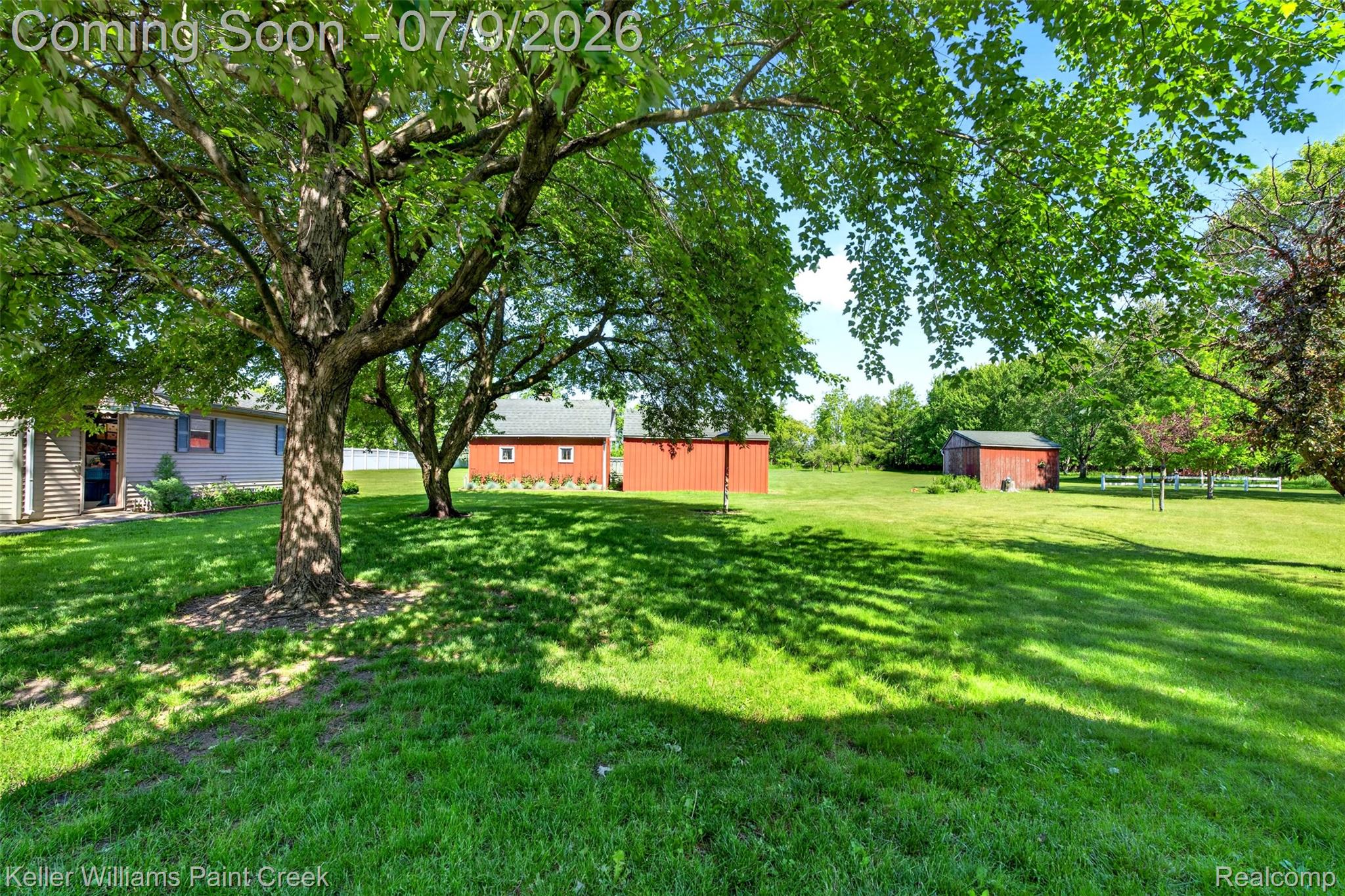 204 Russell Road Kawkawlin, MI 48631 - Photo 8 of 82 Expansive green lawn with mature trees providing dappled shade