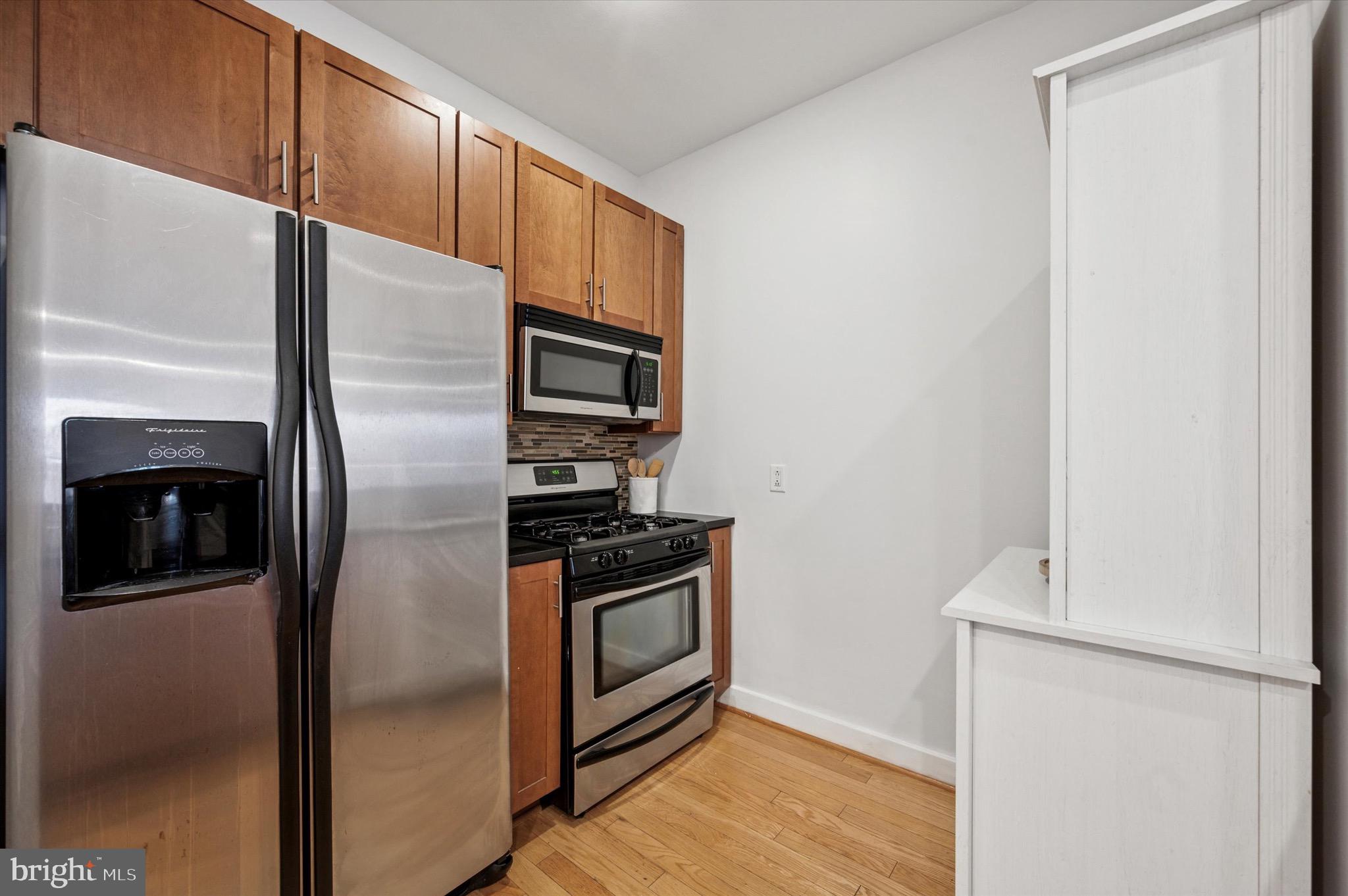 714 Bainbridge Street, Unit 9 Philadelphia, PA 19147 - Photo 11 of 25 a metallic refrigerator freezer and a stove sitting inside of a kitchen
