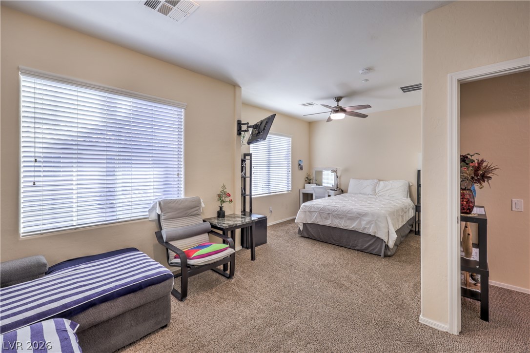 4705 Apulia Drive, Unit 203 North Las Vegas, NV 89084 - Photo 16 of 39 Carpeted floors and tall windows define this inviting bedroom, offering a restful retreat.