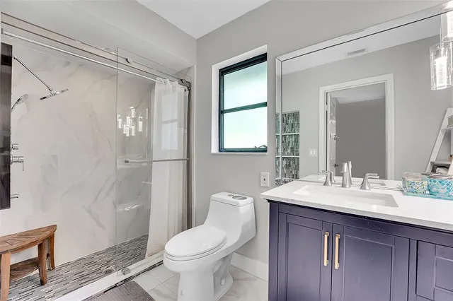 a bathroom with a sink a toilet and shower