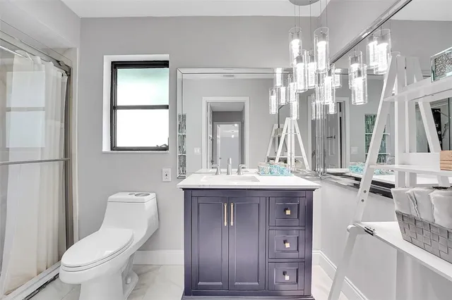 a bathroom with a granite countertop sink toilet and shower