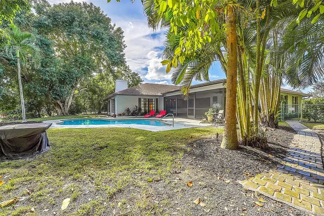 a view of house with backyard space and swimming pool