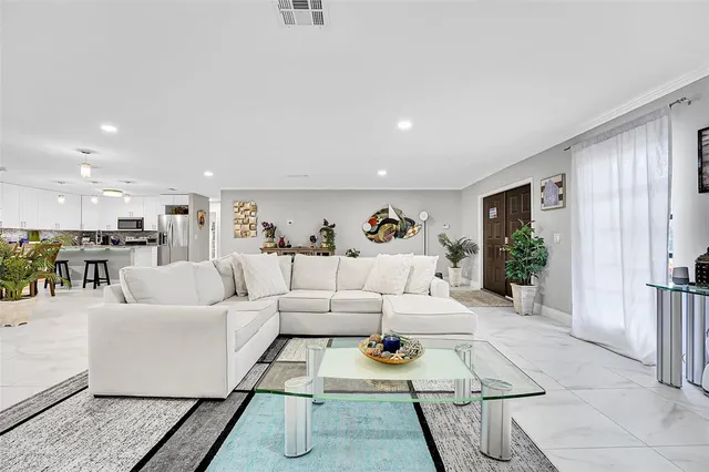 a living room with furniture kitchen view and a table