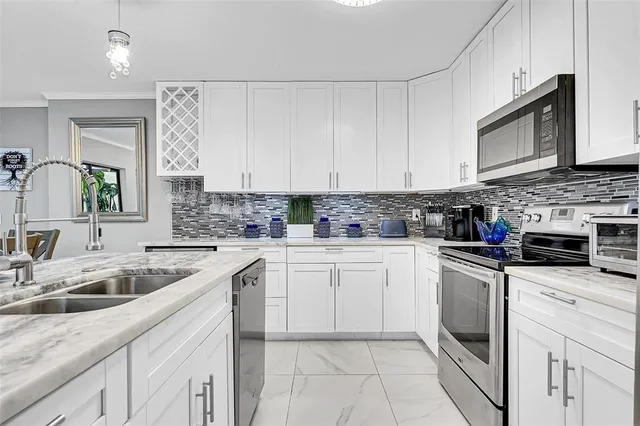 a kitchen with cabinets appliances a sink and a counter top space