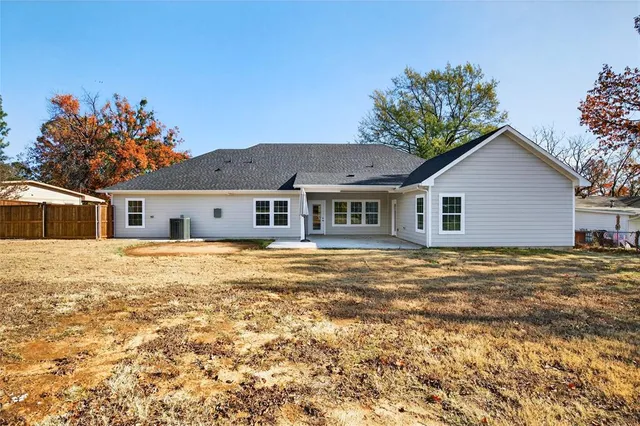 a front view of house with yard and trees in the background
