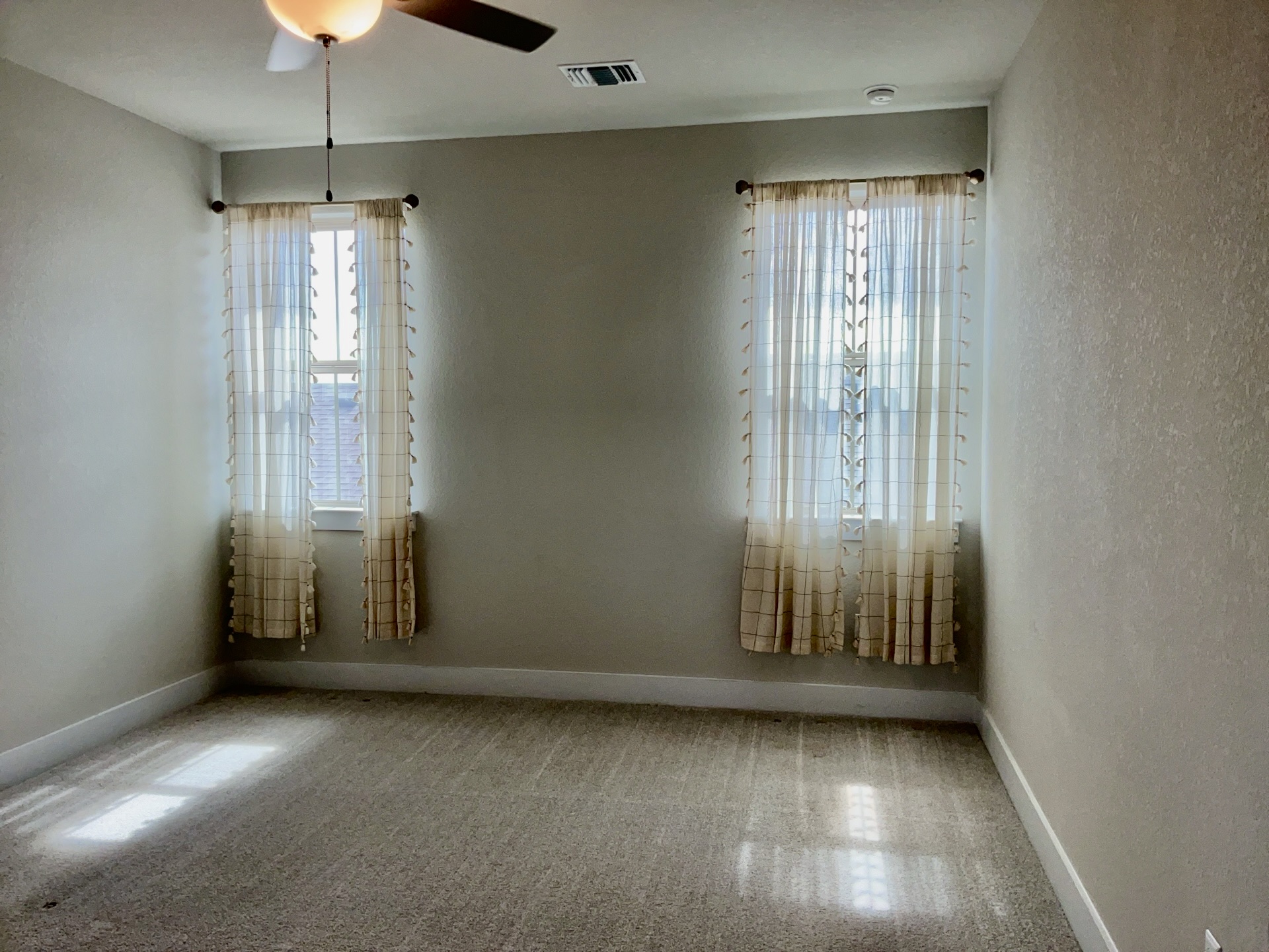 8315 Laughlin Lane Austin, TX 78744 - Photo 9 of 23 an empty room with chandelier fan and windows