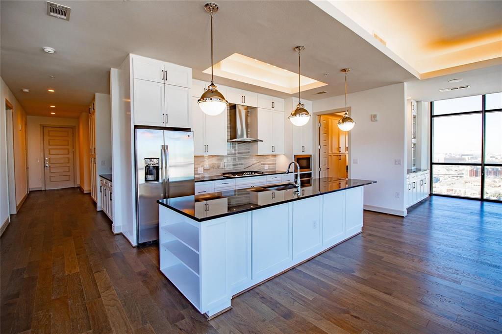 a kitchen with stainless steel appliances granite countertop wooden floors sink and cabinets