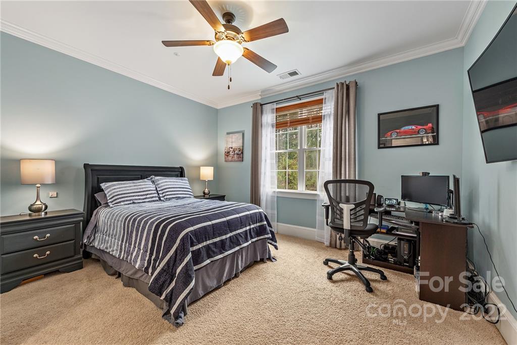 15501 Eagleview Drive Charlotte, NC 28278 - Photo 35 of 40 a bedroom with a bed a desk and a chandelier