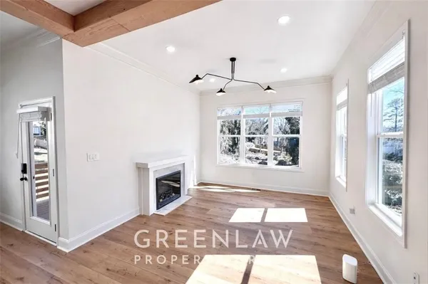 a view of an empty room with a window and kitchen view