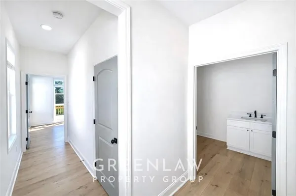 a view of a hallway with closet and wooden floor