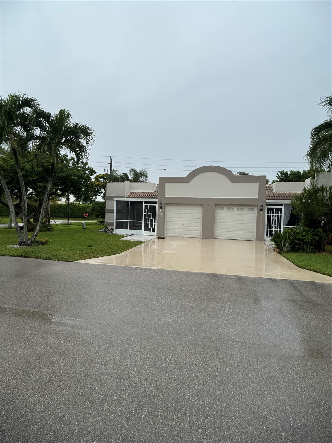 9245 Flynn Circle, Unit 8 Boca Raton, FL 33496 - Photo 2 of 36 a house with a yard and a large parking space