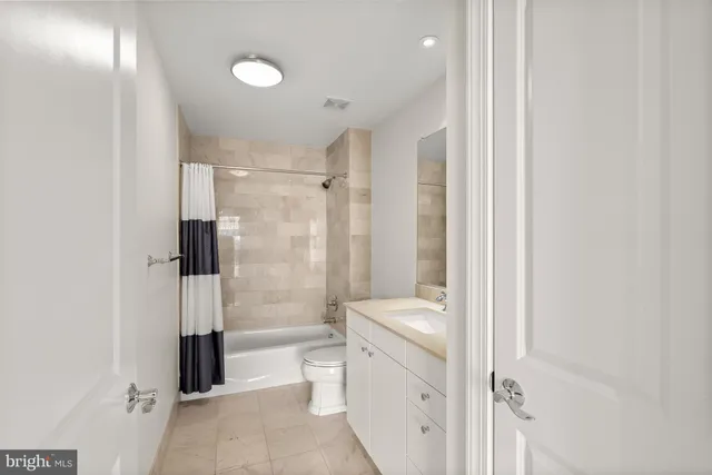 a bathroom with a shower a toilet and a glass door