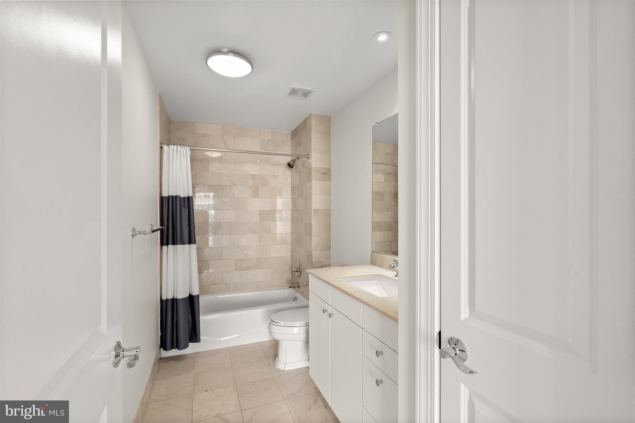 2425 L Street Northwest, Unit 709 Washington, DC 20037 - Photo 12 of 24 a bathroom with a shower a toilet and a glass door