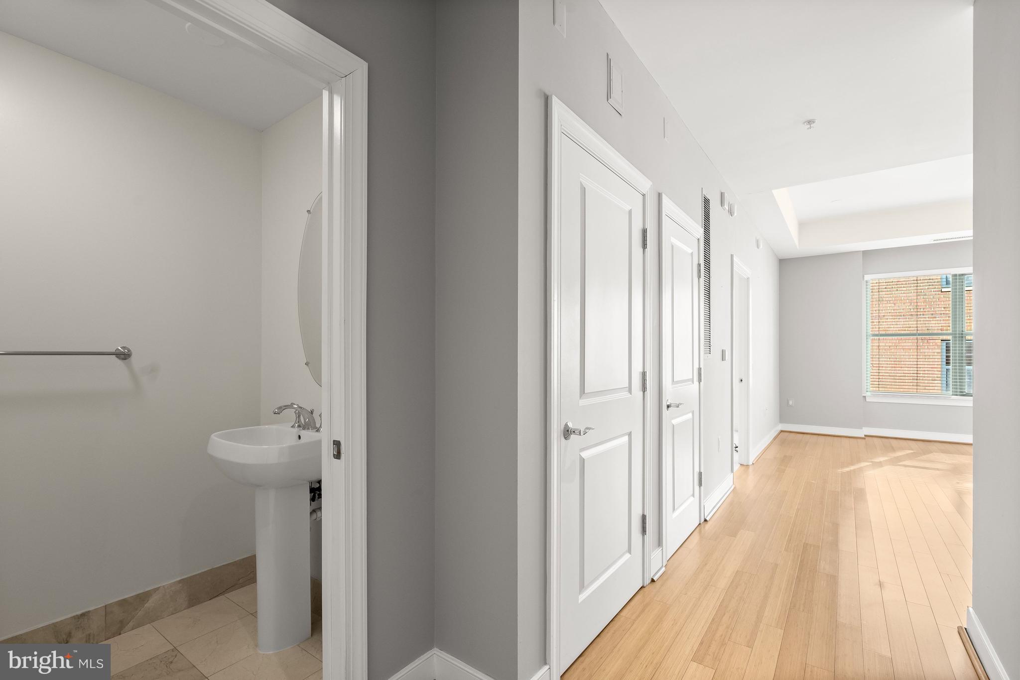2425 L Street Northwest, Unit 709 Washington, DC 20037 - Photo 4 of 24 a view of a bathroom with a sink and mirror