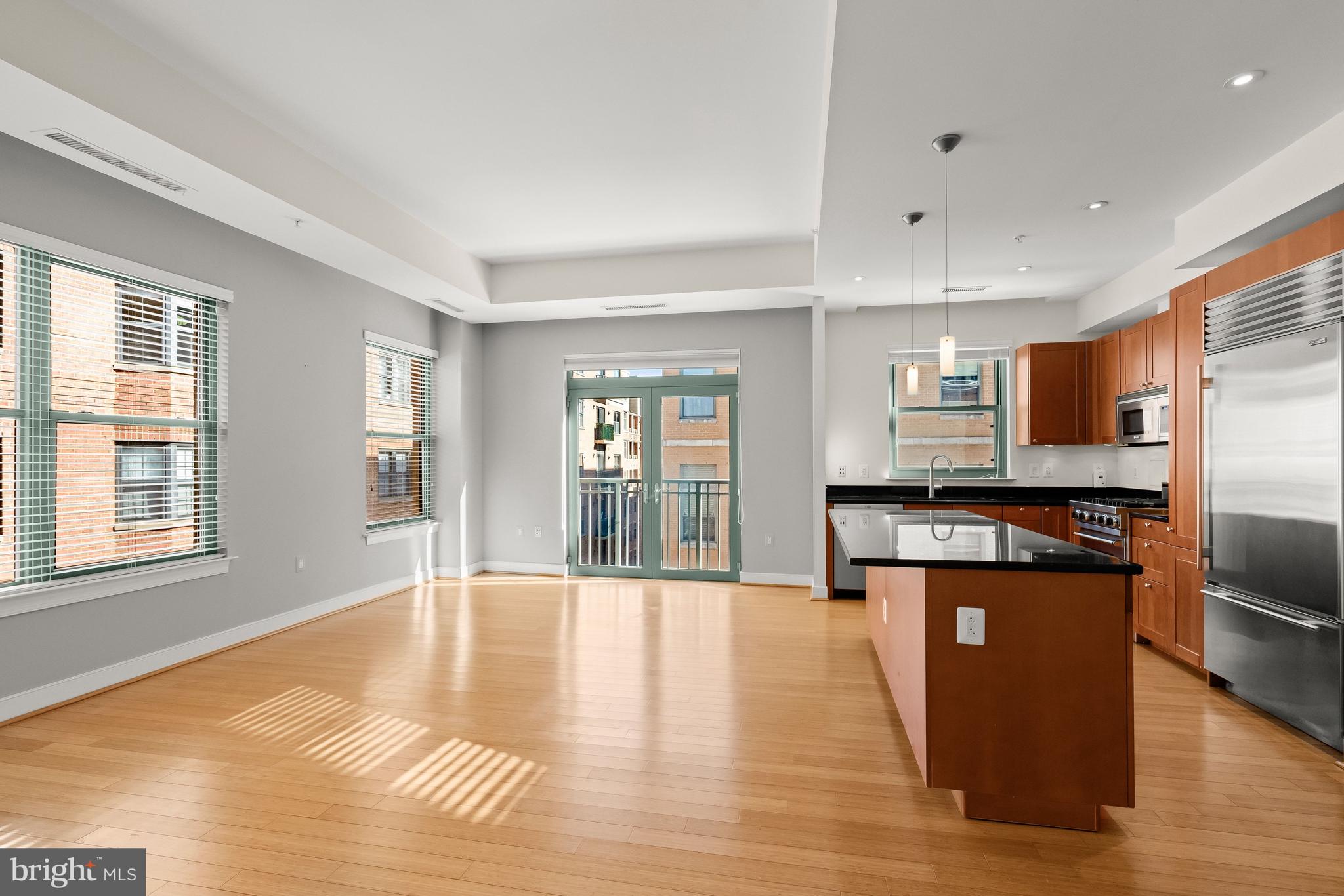 2425 L Street Northwest, Unit 709 Washington, DC 20037 - Photo 5 of 24 a open kitchen with stainless steel appliances granite countertop a refrigerator a stove top oven and a dishwasher with wooden floor