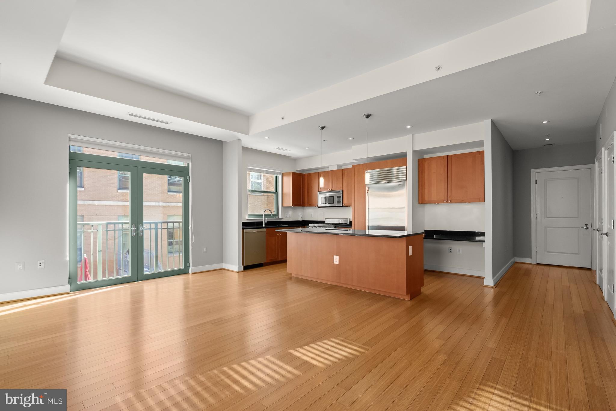 2425 L Street Northwest, Unit 709 Washington, DC 20037 - Photo 7 of 24 a large kitchen with stainless steel appliances wooden floor and a large window