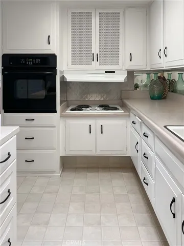 a kitchen with granite countertop white cabinets and stainless steel appliances