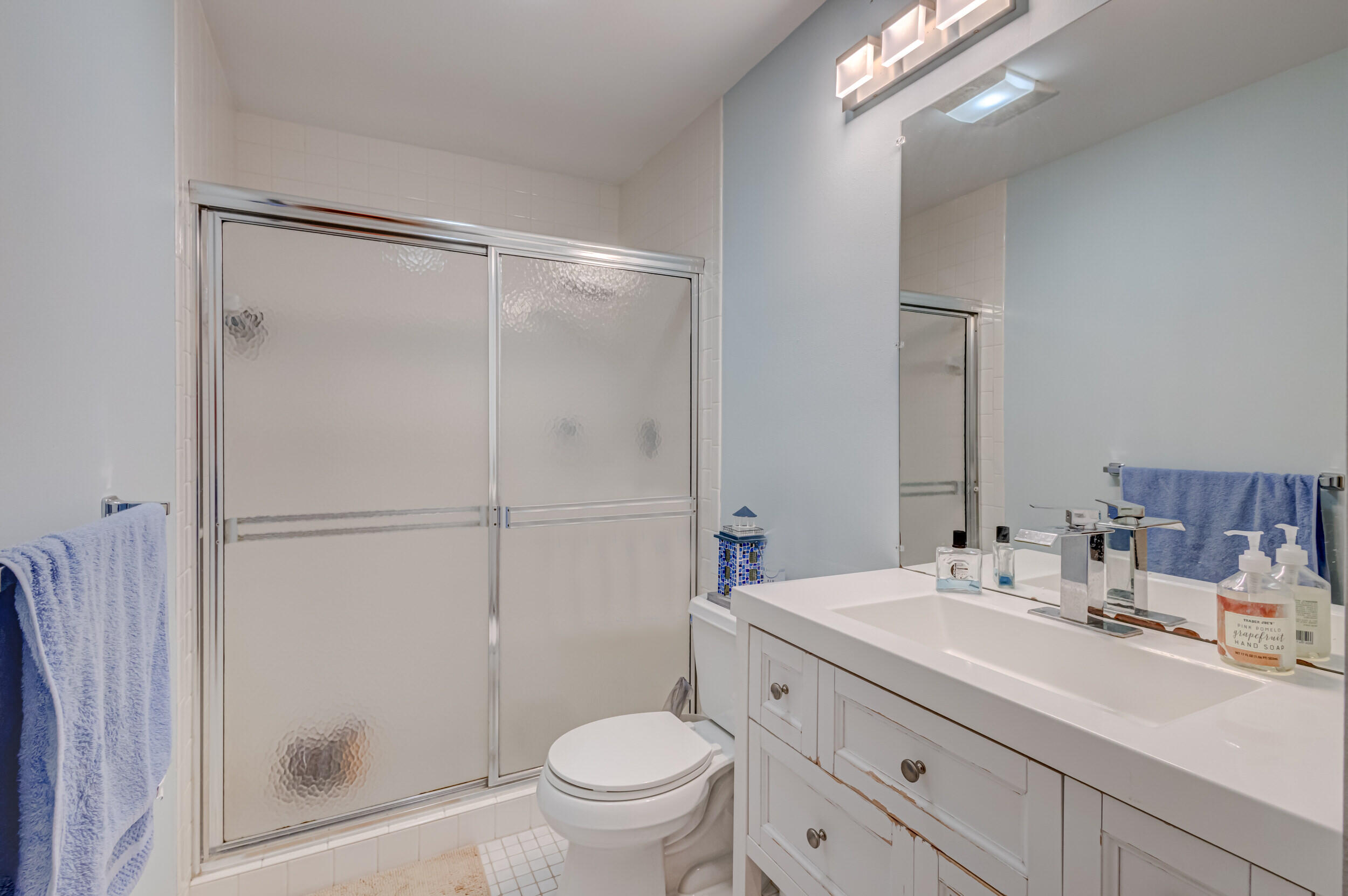 3793 Cape Pointe Circle Jupiter, FL 33477 - Photo 16 of 20 a bathroom with a shower sink vanity mirror and toilet