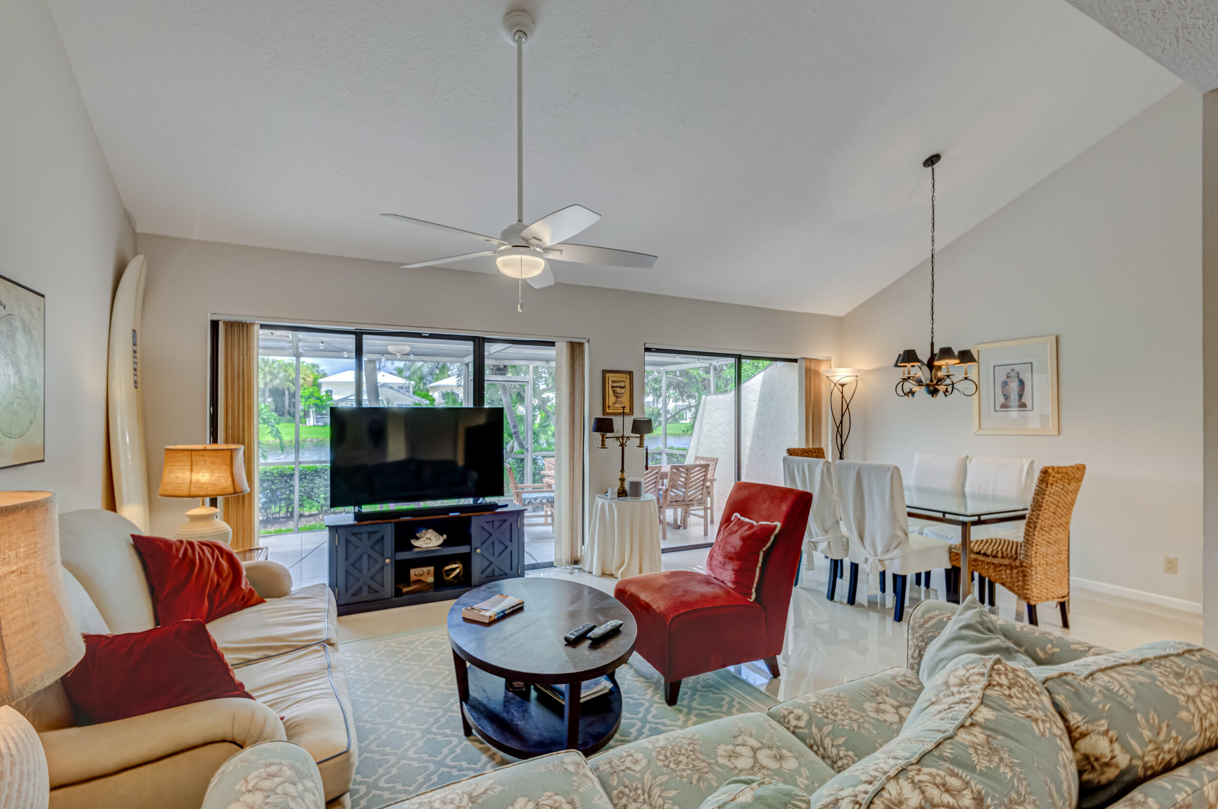 3793 Cape Pointe Circle Jupiter, FL 33477 - Photo 3 of 20 a living room with furniture a flat screen tv and a chandelier