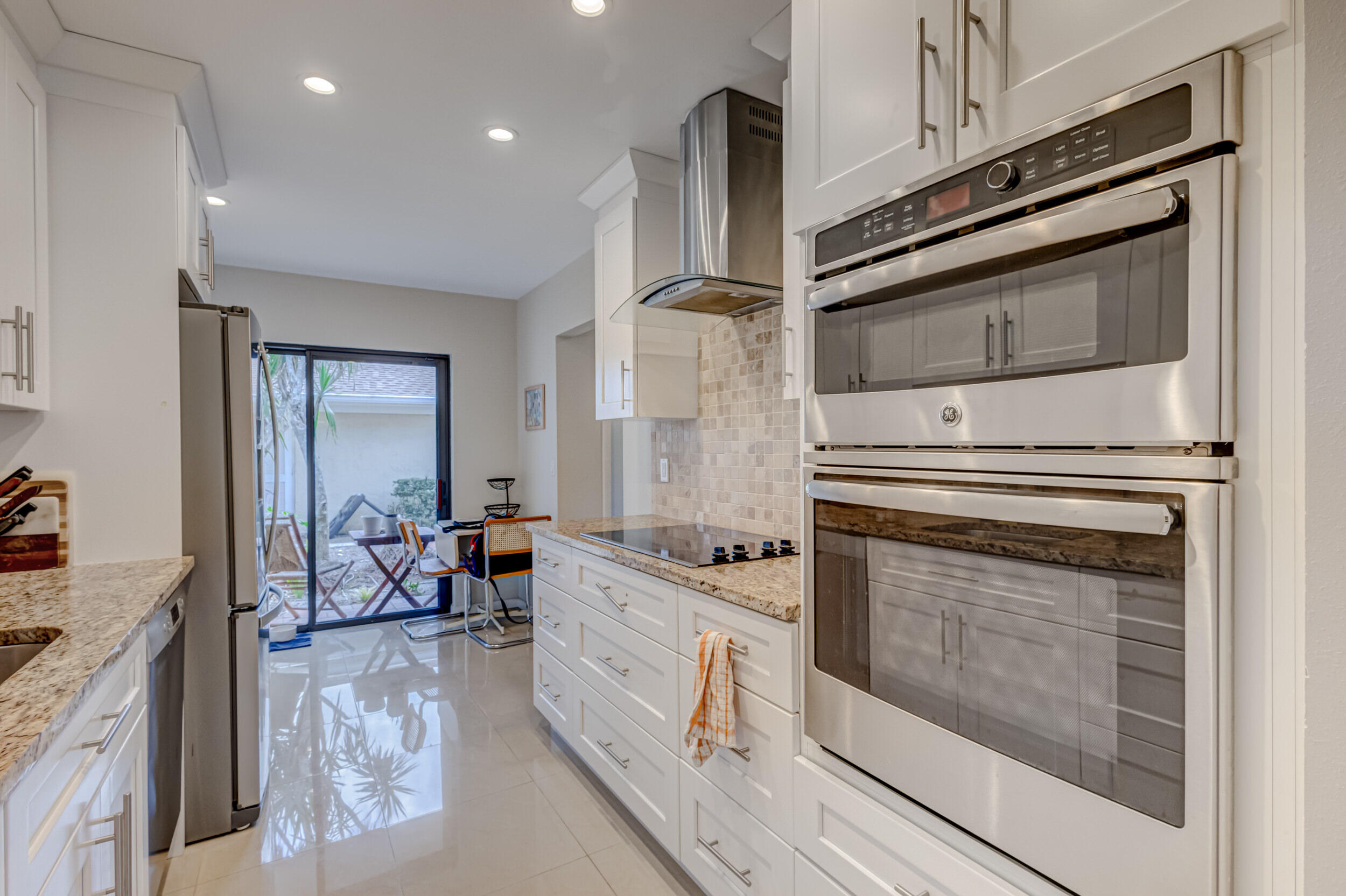 3793 Cape Pointe Circle Jupiter, FL 33477 - Photo 7 of 20 a kitchen with stainless steel appliances granite countertop a stove and a refrigerator