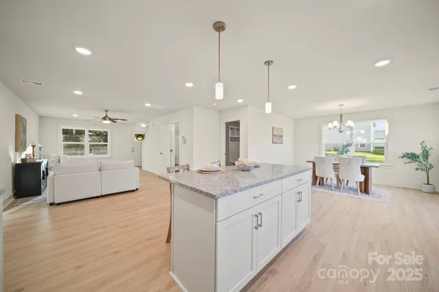 a large white kitchen with a large counter space and stainless steel appliances