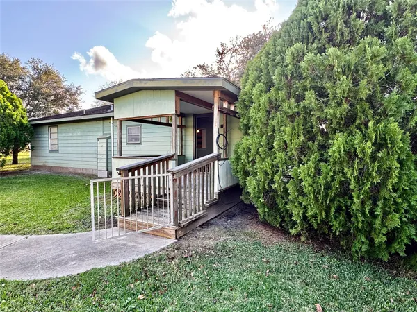 a front view of a house with a garden and deck