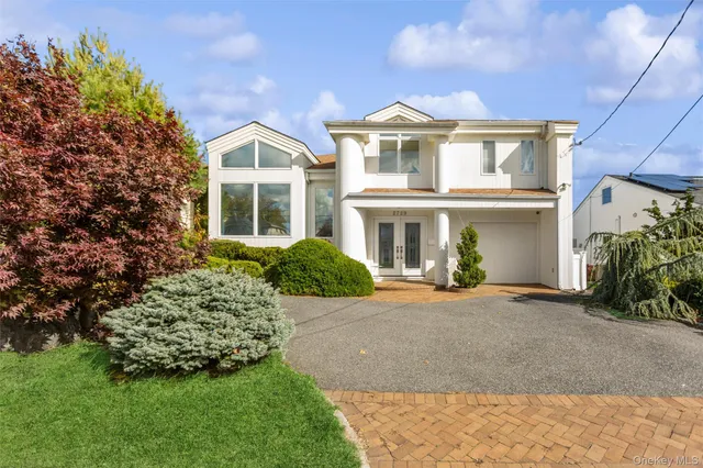 a front view of a house with a garden and plants