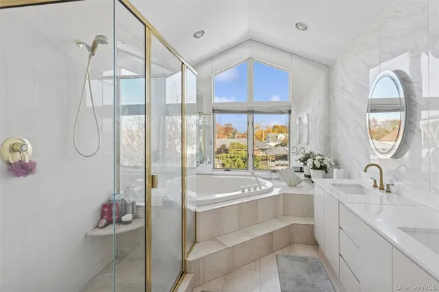 a bathroom with a tub sink and mirror