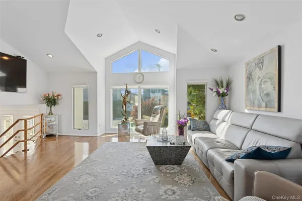 a living room with furniture a flat screen tv and a large window