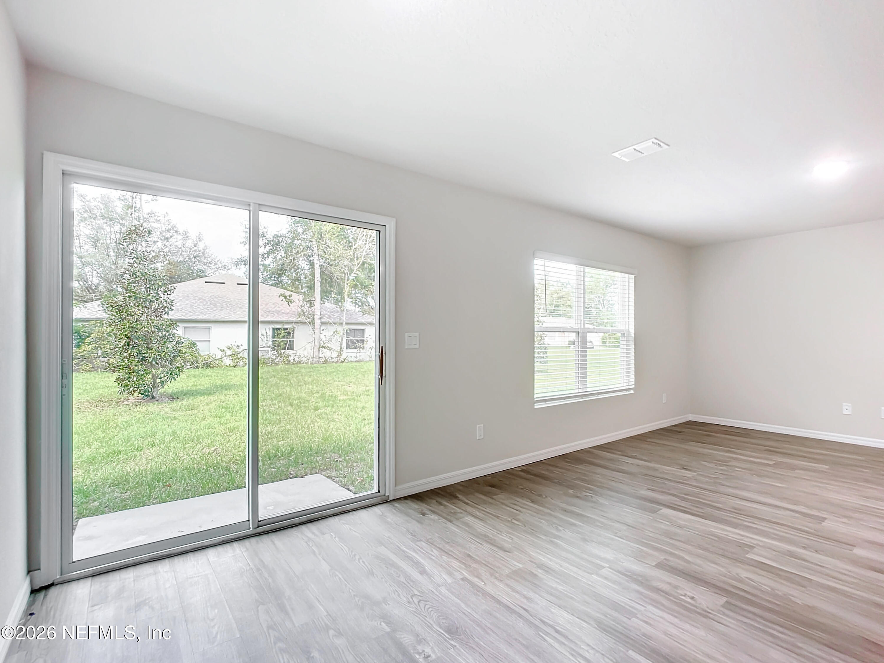 66 Rickenbacker Drive Palm Coast, FL 32164 - Photo 6 of 8 a view of an empty room with wooden floor and a window