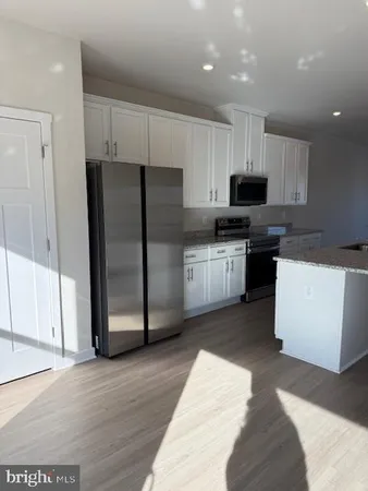 a kitchen with stainless steel appliances kitchen island a refrigerator sink and cabinets