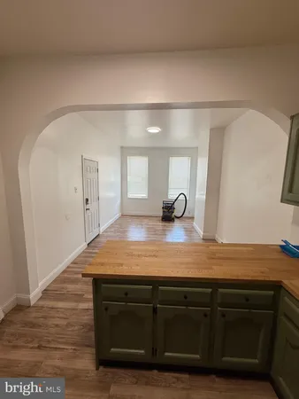 a view of a hallway with wooden floor and cabinets