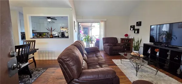 a living room with furniture a flat screen tv and a large window