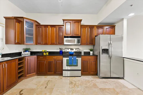 a kitchen with stainless steel appliances granite countertop a refrigerator stove and a sink