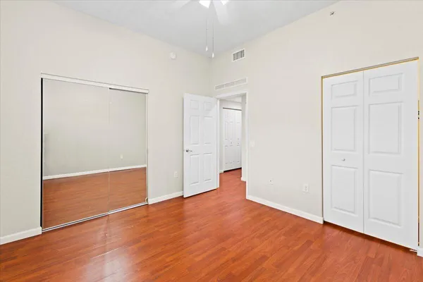 an empty room with wooden floor and closet