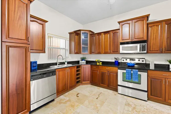 a kitchen with stainless steel appliances granite countertop a stove sink and cabinets