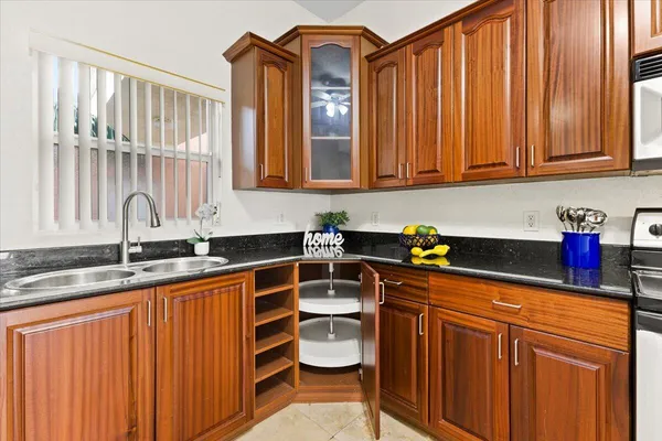 a kitchen with stainless steel appliances granite countertop a sink a stove and cabinets