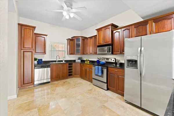 a kitchen with granite countertop stainless steel appliances a refrigerator a stove top oven and a refrigerator