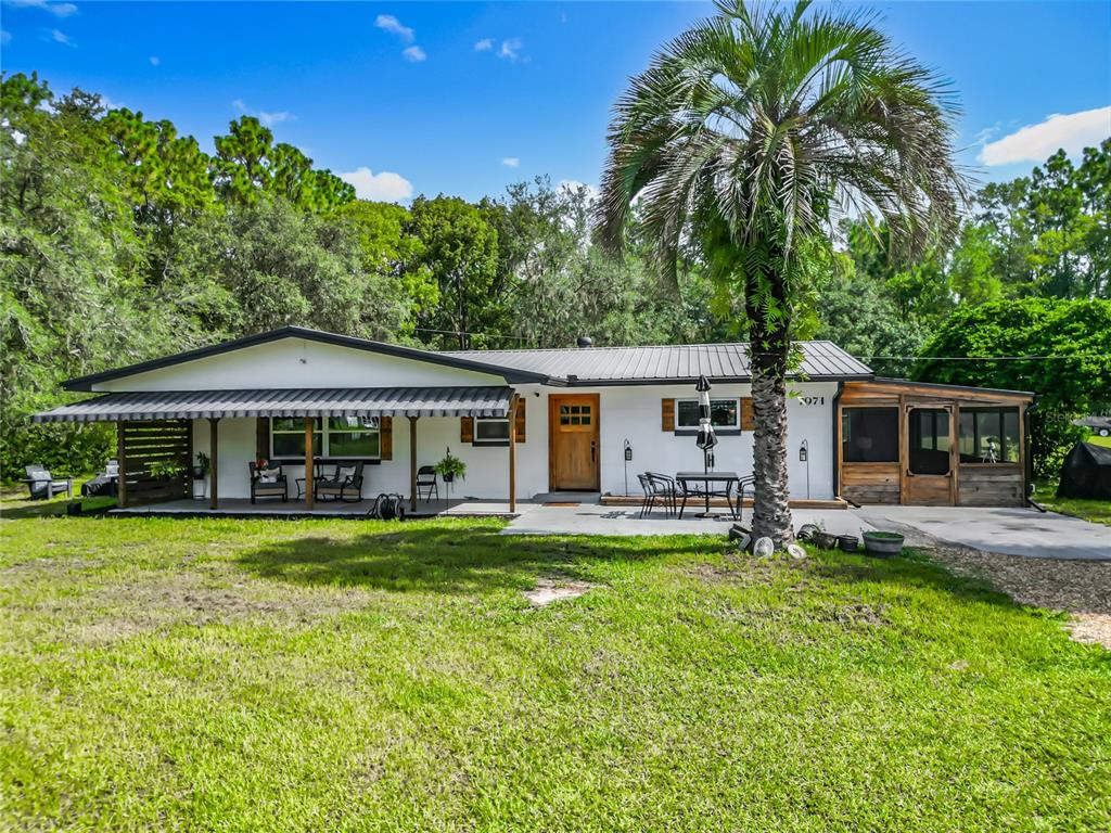 a front view of a house with a garden and trees