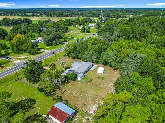 a view of a house with backyard and a tree