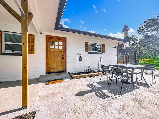 a kitchen with stainless steel appliances granite countertop a stove a refrigerator a sink dishwasher and a dining table with wooden floor